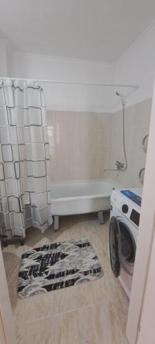 uma lavandaria com uma máquina de lavar roupa e uma banheira em 2-комнатная квартира в административном центре. em Türkistan