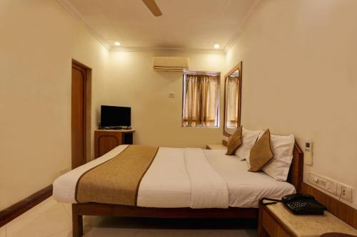 a bedroom with a bed and a television in it at Accord Hotel in Mumbai