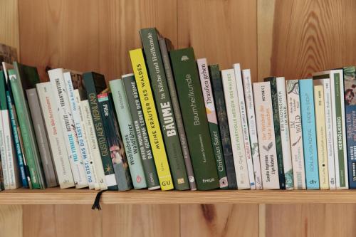 a row of books on a book shelf at baumhaus buchengrün in Dobl-Zwaring