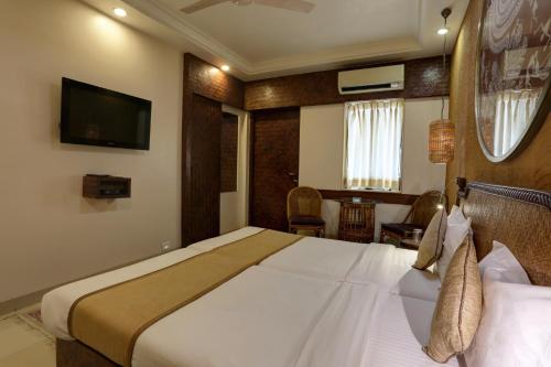 a hotel room with a bed and a television at Accord Hotel in Mumbai