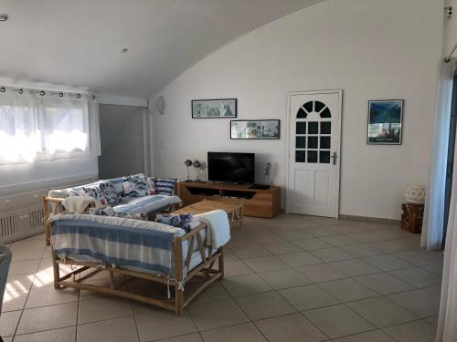 a living room with a couch and a tv at vert lagon in Saint-Pierre