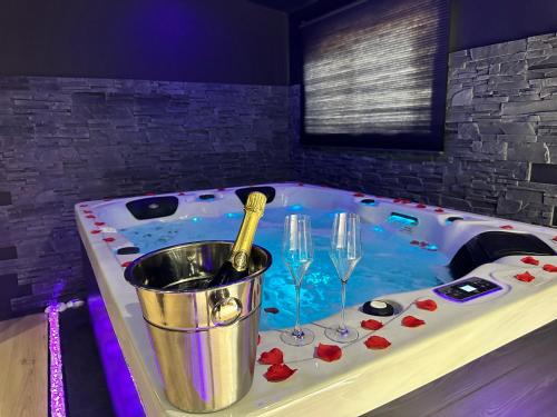 una bañera con una botella de champán y dos copas de vino en Homesuiteandspa en Flers-en-Escribeus