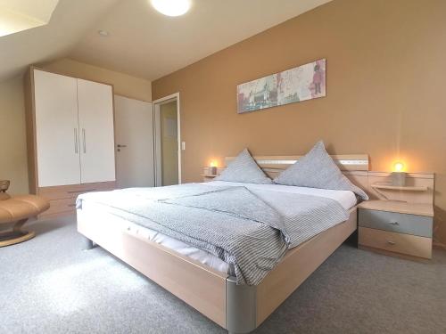 een slaapkamer met een groot wit bed met 2 kussens bij Ferienwohnung Rheintal in Kappel-Grafenhausen
