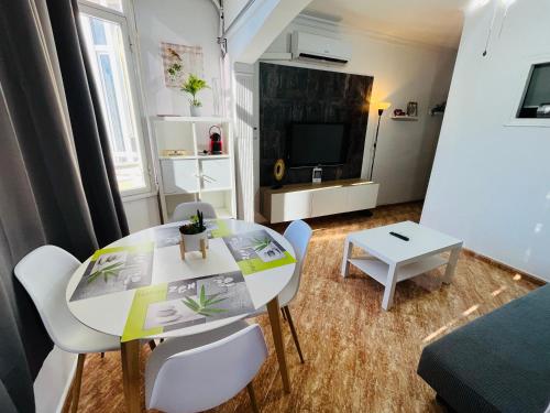 - un petit salon avec une table et des chaises blanches dans l'établissement Casa V&T Torremolinos, à Torremolinos