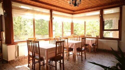 a dining room with tables and chairs and windows at Dibekönü Konak in Safranbolu