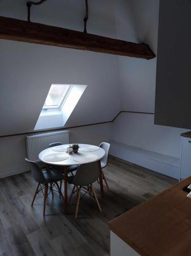 a table and chairs in a room with a window at Apartmány Karolin in Uhorská Ves