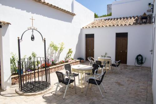un patio con mesas y sillas en un edificio blanco en CASA DE LA SEÑORA en Palma del Río