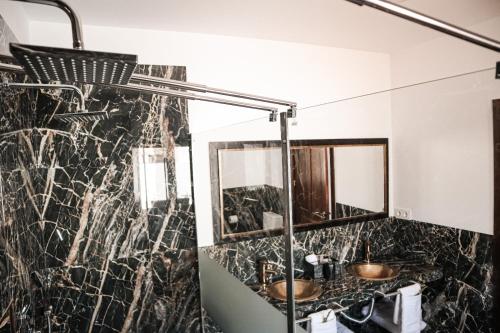 a bathroom with a black and white marble wall at CASA DE LA SEÑORA in Palma del Río