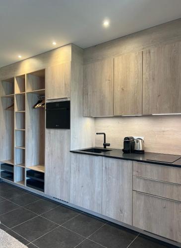 une cuisine avec des armoires en bois et un comptoir dans l'établissement La Merle, à Veyrier-du-Lac