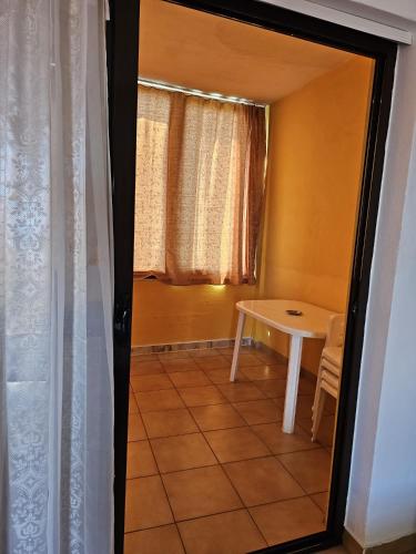 a small room with a table and a window at Sokol Guest House in Velipojë