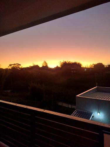 a view of a sunset from a balcony at Suítes do Vale - Praia do Rosa in Imbituba