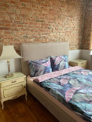 1 dormitorio con cama y pared de ladrillo en Apartments PSD - Wojska Polskiego 6, en Słupsk