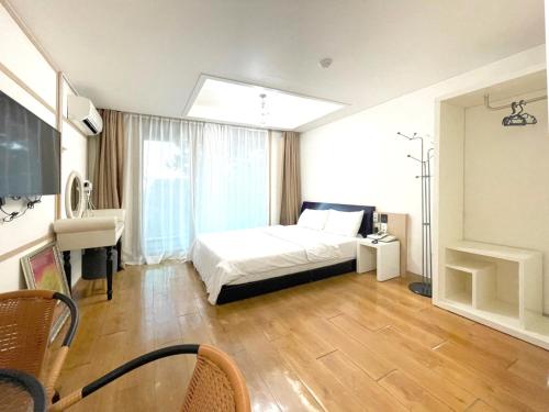 una camera con letto e scrivania di Cordelia Resort a Seogwipo