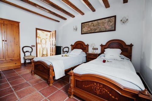 two beds in a room with white walls at Masía Can Viver in Bigues i Riells