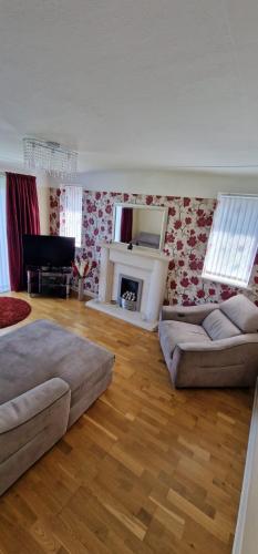 a living room with two couches and a fireplace at Linksway House in Birkenhead