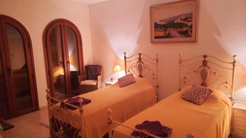 1 Schlafzimmer mit 2 Betten und einem Spiegel in der Unterkunft Loma del Rey 56 - casa primera linea de mar in Alcaidesa