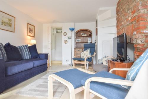 a living room with a couch and a tv at Mulberry Cottage in Cowes