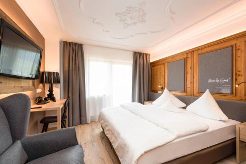 a hotel room with a large bed and a couch at Hotel Stubaierhof in Neustift im Stubaital