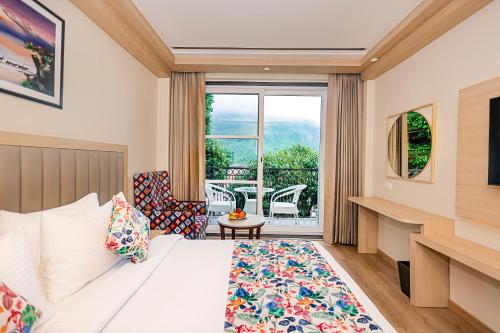 a hotel room with a bed and a balcony at Regenta Inn Luxinna Heights Mcleodganj in Dharamshala