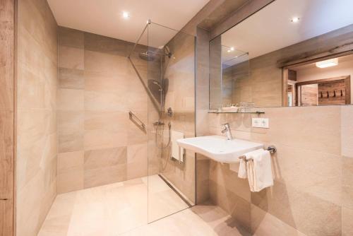 a bathroom with a sink and a shower at Hotel Stubaierhof in Neustift im Stubaital