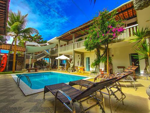 a house with a swimming pool in front of a house at Pousada Água de Fuego in Maragogi