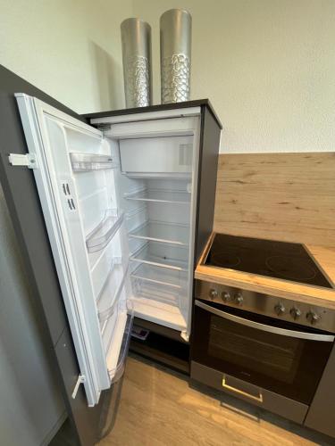 an empty refrigerator with its door open in a kitchen at Altstadtwohnung - Old Town in Trostberg an der Alz