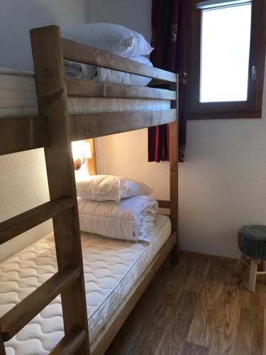 two bunk beds in a room with a window at Appartement 4-6 personnes à Valmeinier 1800 résa du samedi au samedi avec piscine intérieure chauffée in Valmeinier
