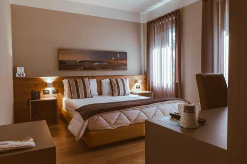 een hotelkamer met een bed en twee tafels bij Hotel Patriarchi in Aquiléia