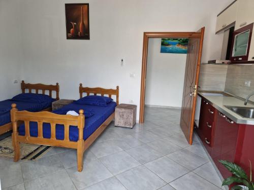 a bedroom with two beds and a kitchen with a sink at Bar-Restaurant-Hotel-Familja in Klos