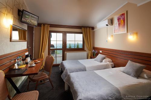 a hotel room with two beds and a desk at Hotel Beskidzki Raj Medical SPA in Stryszawa