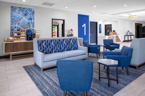 a waiting room with a couch and blue chairs at Holiday Inn Express Hotel & Suites Hermosa Beach by IHG in Hermosa Beach