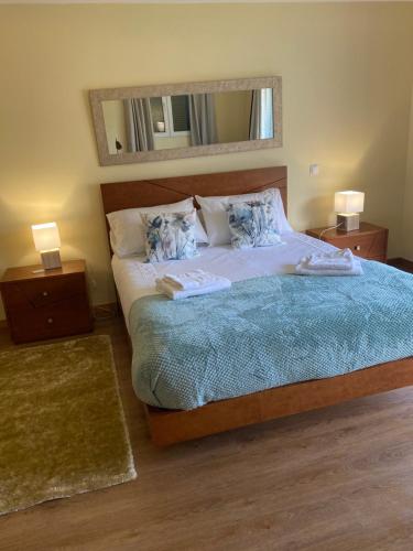 um quarto com uma cama grande e 2 mesas de cabeceira em Casa do Cantinho do Muro em São Vicente