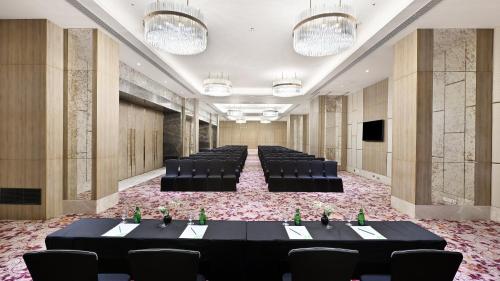 a banquet hall with black tables and chairs and lights at Holiday Inn Gurugram Sector 90 by IHG in Gurgaon
