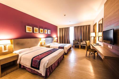 um quarto de hotel com duas camas e uma televisão de ecrã plano em Badi'ah Hotel em Bandar Seri Begawan