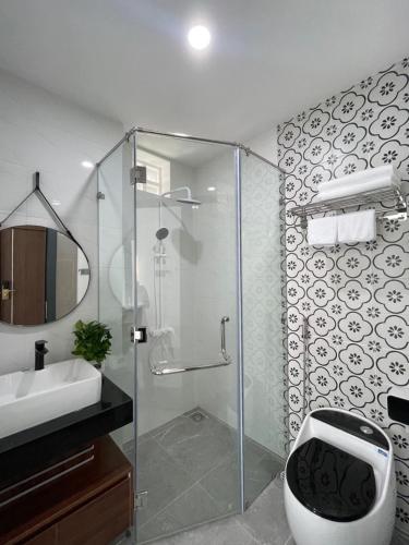 a bathroom with a shower with a toilet and a sink at Bel-air Hotel in Quy Nhon