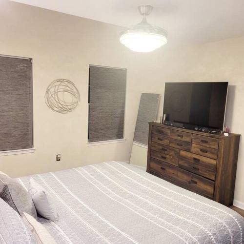 a bedroom with a bed and a flat screen tv at Modern & Luxurious 3 Bdrm 2.5 Bath Townhome in Apex