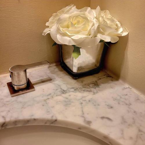a vase with a white rose on top of a toilet at Modern & Luxurious 3 Bdrm 2.5 Bath Townhome in Apex
