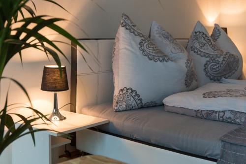 Bett mit Kissen und Tisch mit Lampe in der Unterkunft Haus der Erholung West in Krems an der Donau
