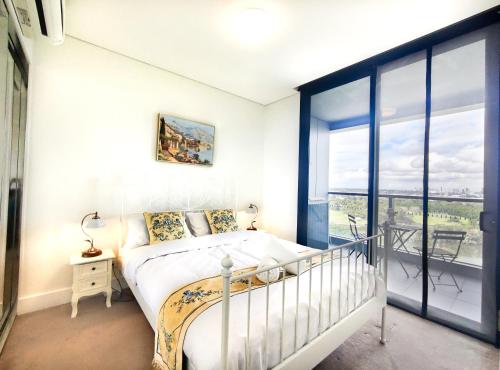 a bedroom with a bed and a large window at Cozy Apt w Park View by Stadiums in Sydney
