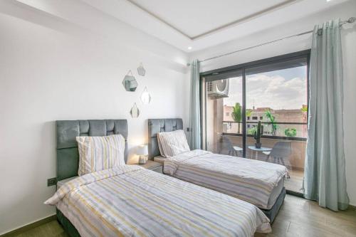 een slaapkamer met 2 bedden en een balkon bij Confort et élégance, résidence Menara garden in Marrakesh