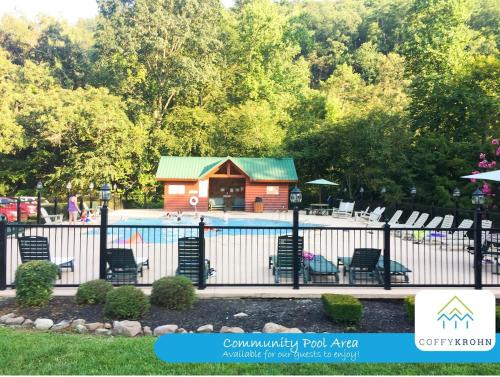 a pool area with chairs and a cabin at Elegant & Cozy Cabin Near Pigeon Forge in Sevierville
