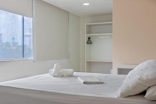 a white bed with white sheets and towels on it at Falcão Hotel Arapiraca in Arapiraca