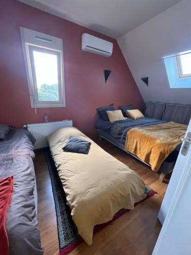a bedroom with two beds and a couch and a window at Les Mottes in Gandelain