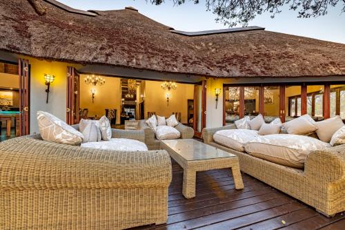 a patio with couches and a table on a deck at Kusudalweni Safari Lodge & Spa in Guernsey Nature Reserve