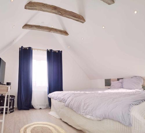 Villa Vandkant في Thyholm: غرفة نوم بسرير كبير مع ستائر زرقاء