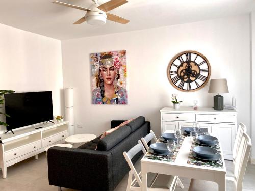 sala de estar con sofá negro y mesa en Apartamento Luz de Conil. WIFI+A/C. SOLO FAMILIAS Y PAREJAS, en Conil de la Frontera