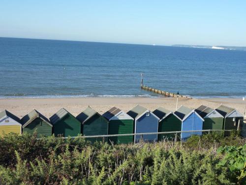 uma fila de coloridas cabanas de praia numa praia em Two rivers reach em Iford