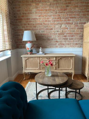 a living room with a table and a brick wall at Apartments PSD - Wojska Polskiego 5 in Słupsk
