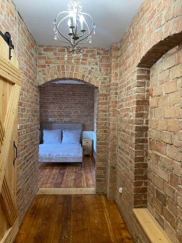 a brick room with a bed in a brick wall at Apartments PSD - Wojska Polskiego 5 in Słupsk