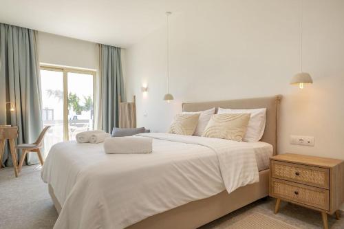 ゲオルギオポリスにあるGolden sea suitesの大きな白いベッドと窓のある寝室